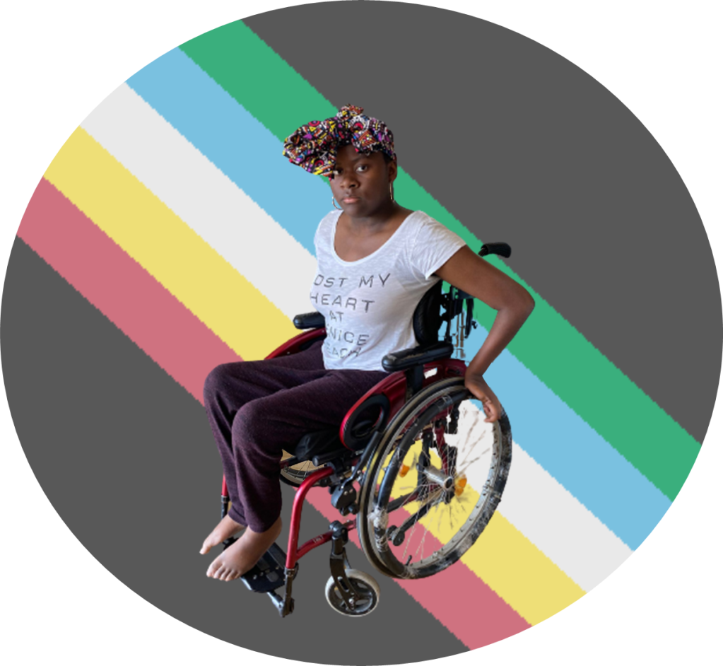 A picture of me in my wheelchair with the Disability pride flag behind me