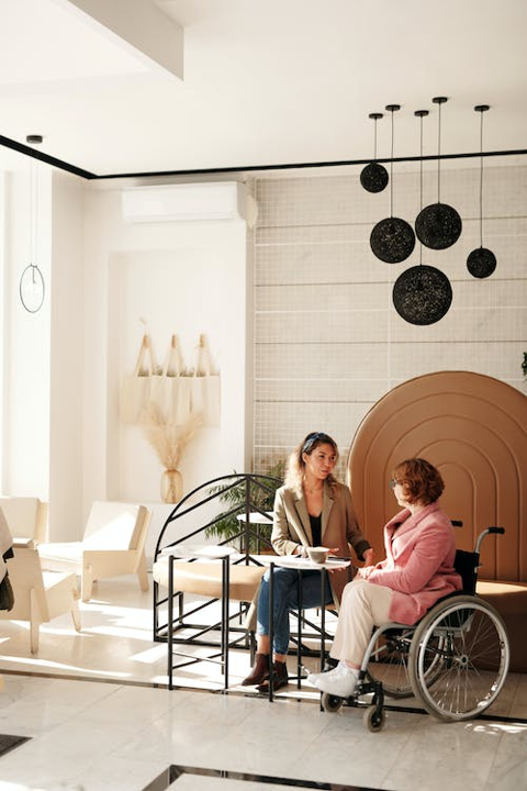 Image of a woman in a wheelchair talking to someone in person 